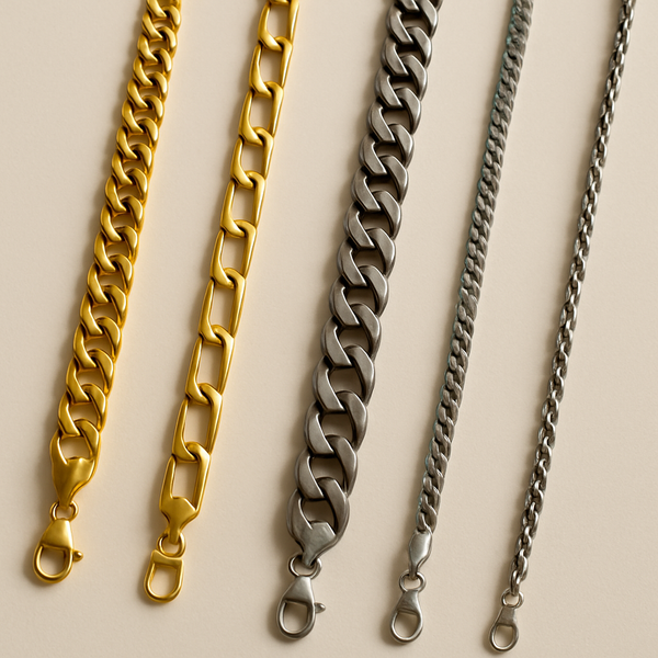 Four men’s stainless steel chains in gold and silver laid out diagonally on a neutral background, showcasing Cuban, link, and rope styles.