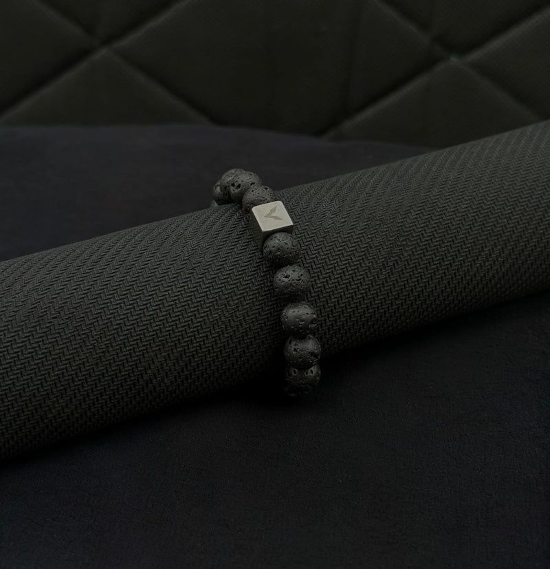 Black beaded bracelet on a black armrest