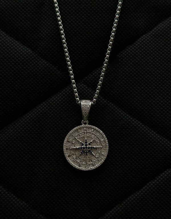 Silver compass pendant necklace on a black textured background