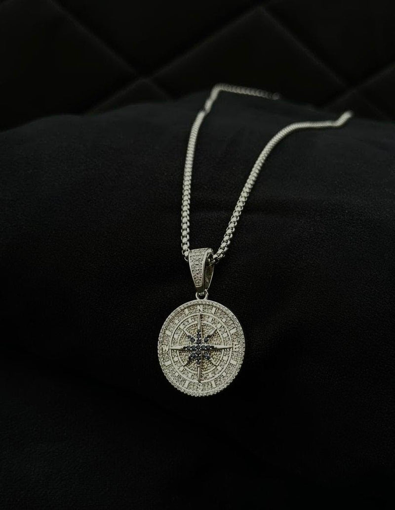 Silver compass pendant necklace on a black background