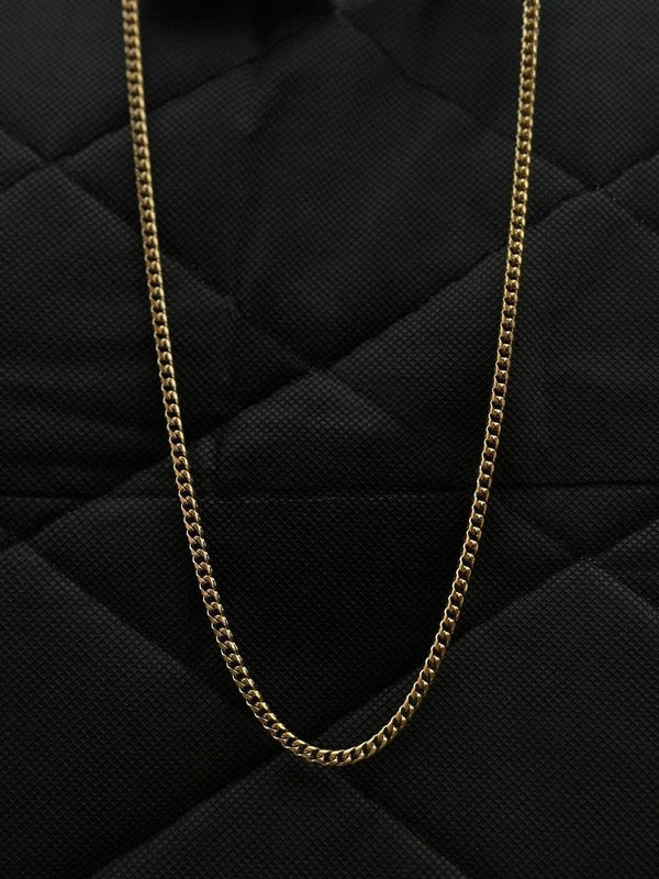 Gold chain on a black quilted surface