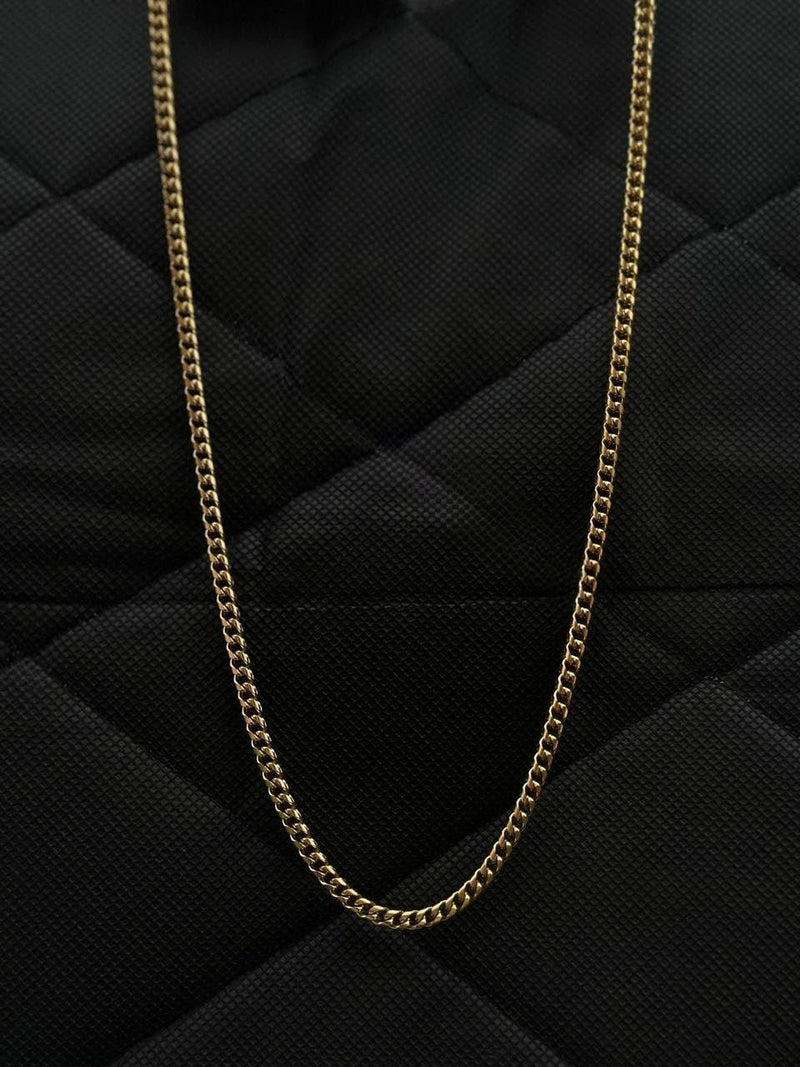 Gold chain on a black quilted surface