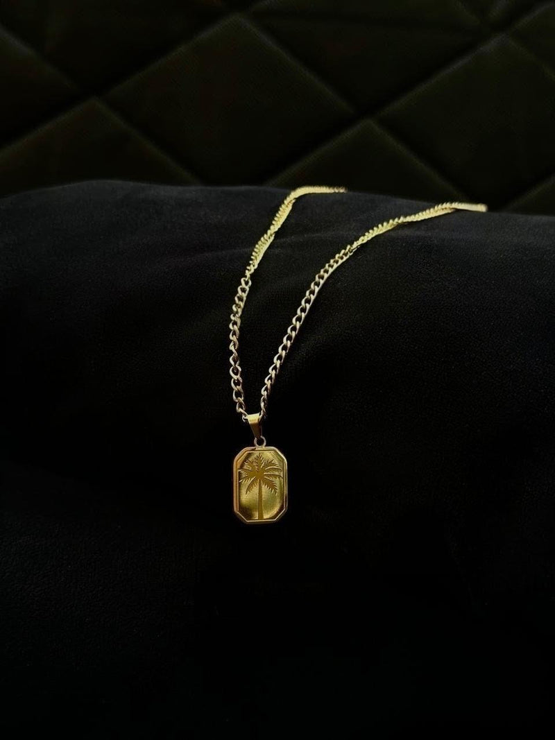 Gold necklace with a pendant on a black quilted surface