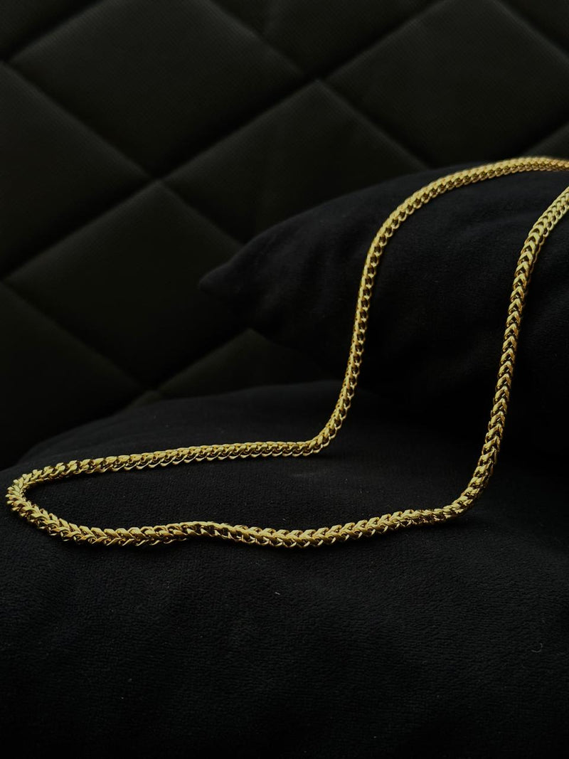Gold chain on a black quilted surface