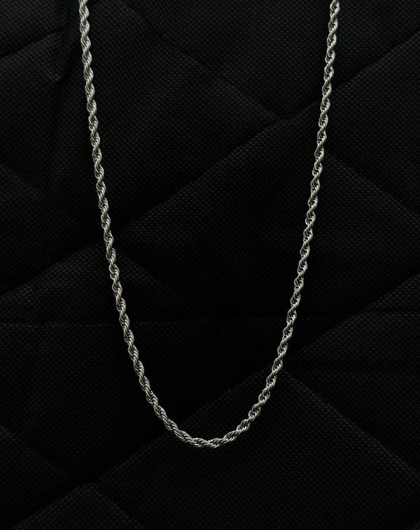 Silver chain necklace on a black textured background