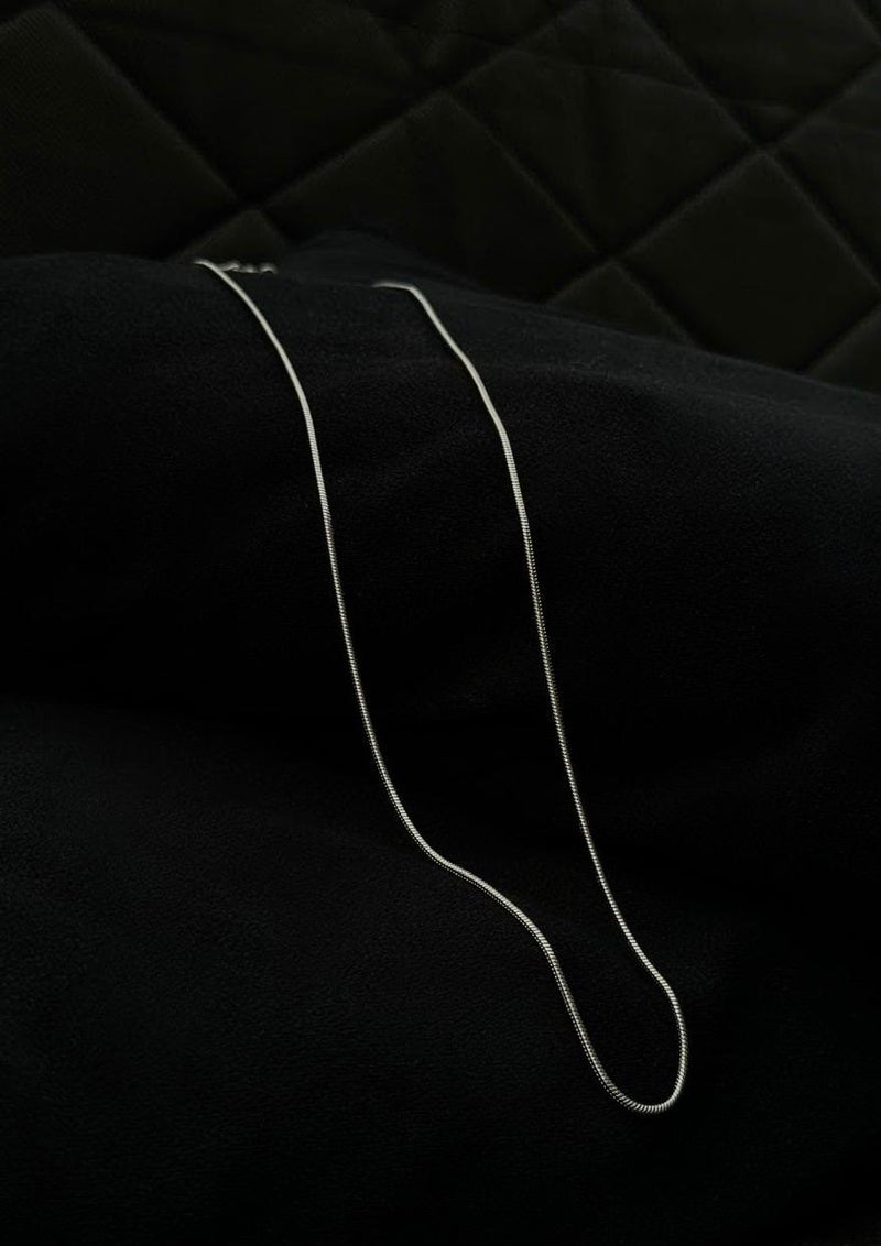 Silver necklace on a black fabric background